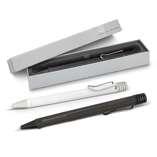 A collection of Lamy Safari pens in black, green, and white, displayed in a box with a soft interior.