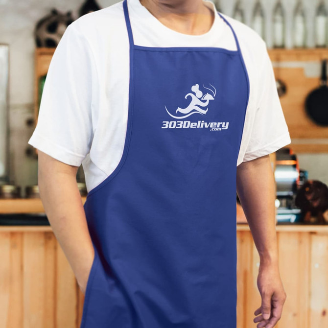 A blue bib apron featuring a logo, displayed on a person in a kitchen setting.