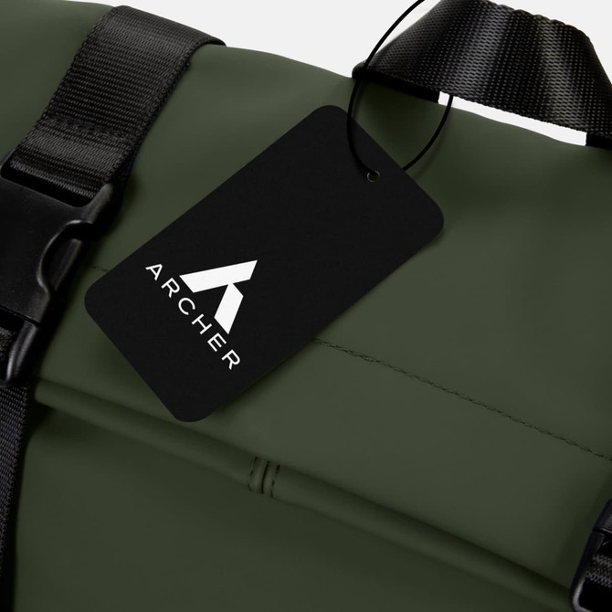 A green soft-touch flap backpack featuring a black tag with a logo. The backpack has adjustable straps for comfort.