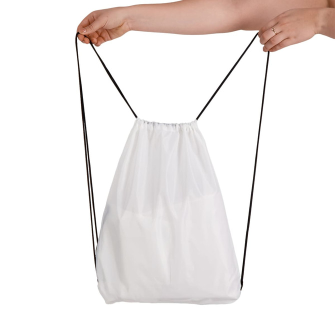 A white drawstring backpack being held by a hand, featuring a simple design and black drawstrings.