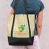 A cream and black tote bag with a logo, featuring a plant design and a person holding it over their shoulder.