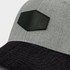 A grey cap with a black brim and a green patch. It features a logo on the patch and a textured finish.