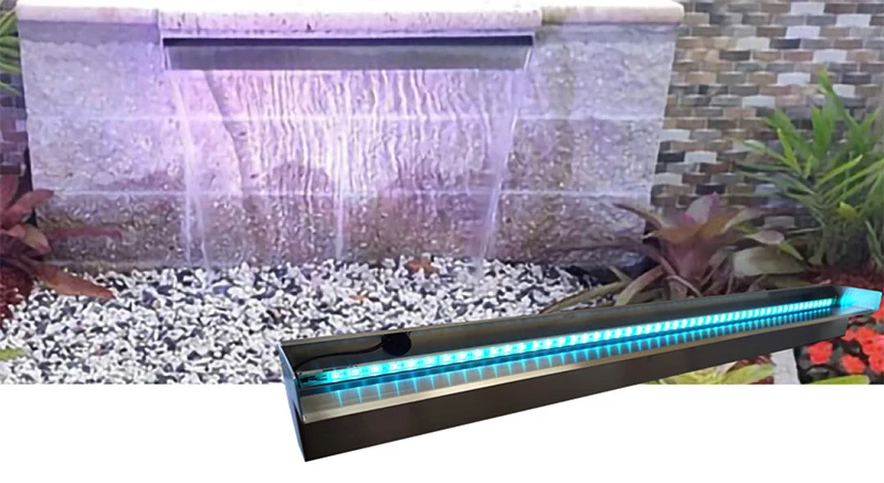 Black stainless steel LED waterfall spillway shown installed in a stone wall creating a sheer sheet of falling water, with a close-up of the spillway's illuminated blue LED strip in the foreground