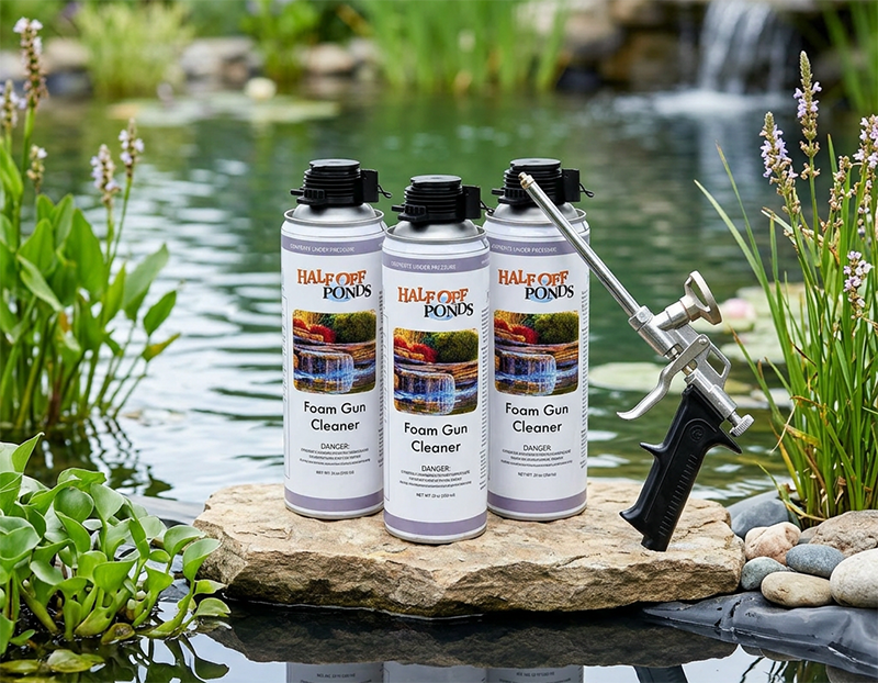 Half Off Ponds Foam Gun Cleaner cans with stainless steel foam dispensing gun displayed on a rock beside a backyard koi pond waterfall.