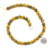 Bumble Bee Jasper 10mm Round natural gemstone beads in yellow, orange, and greenish tones arranged in a 15 inch strand, displayed with a coin for scale. Bumble Bee Jasper 10mm Round natural gemstone beads in yellow, orange, and greenish tones arranged in a 15 inch strand, displayed with a coin for scale.