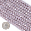 Crystal 5x6mm opaque light lavender purple faceted rondelle beads with AB finish shown beside a dime for size reference.