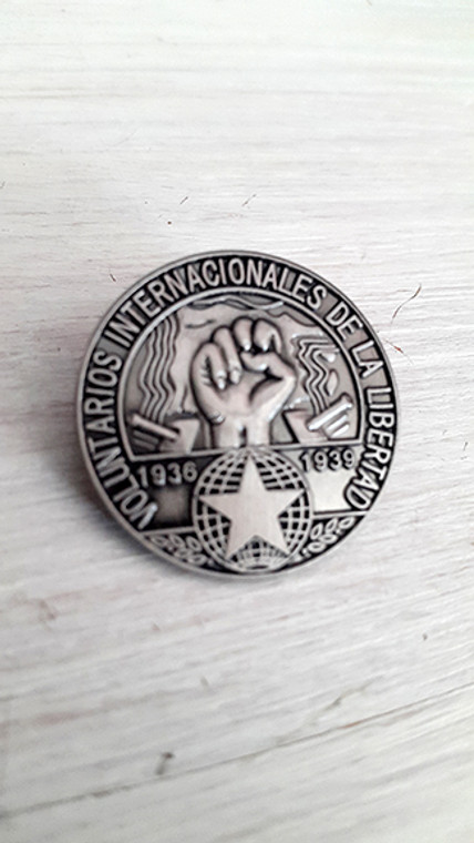 Reproduction of original International Brigade blouson badge with brooch fixing.

3D badge has map of Spain, cannons, clenched fist, star and the text 'Voluntarios Internacionales de la Libertad'.
