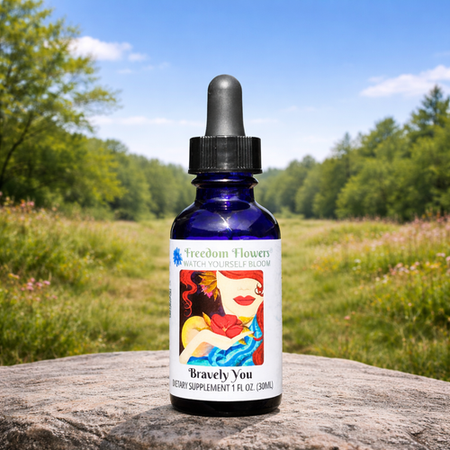 Bottle of Bravely You flower essence placed on a stone in a sunlit meadow with trees in the background.
