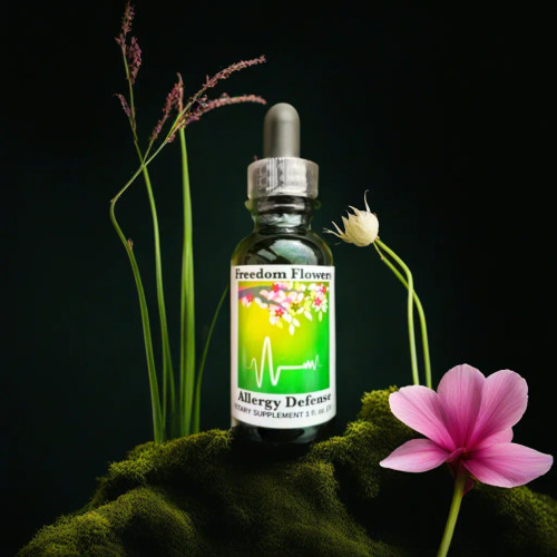 Bottle of Allergy Defense on a mossy rock with a pink flower, black background.