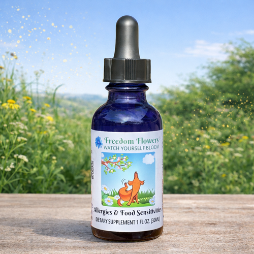 Allergies & Food Sensitivities bottle placed on a wooden surface, with a soft-focus green meadow and floating golden particles in the background.