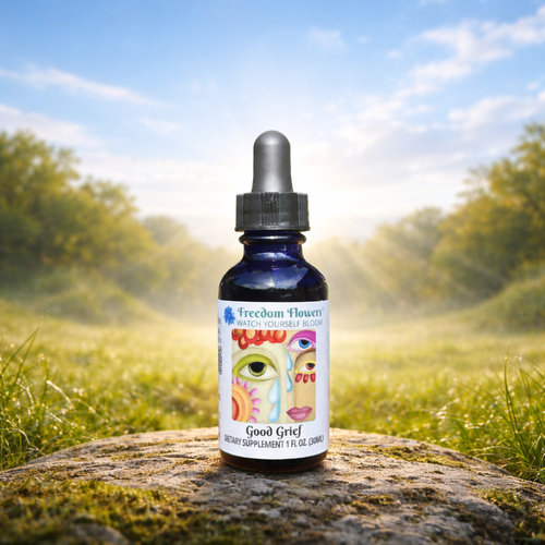 Bottle of Good Grief flower essence placed on a stone in a sunlit meadow with soft morning light in the background.