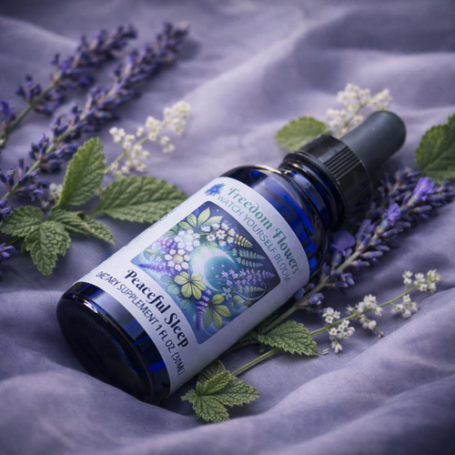 Peaceful Sleep bottle lying on lavender silk with fresh lavender, lemon balm leaves, and small white flowers around it.