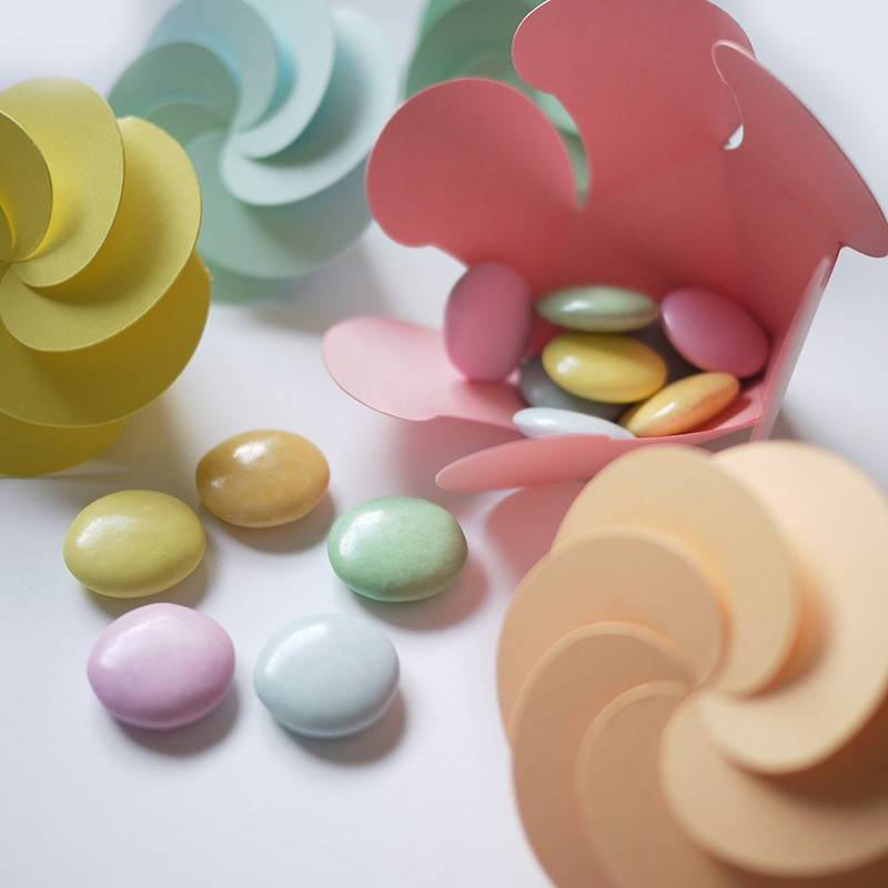 Assortiment des dragées rondes et tendres : chocolat 70% et couleurs pastel.