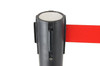 Black retractable belt queue barrier with a red belt in use
