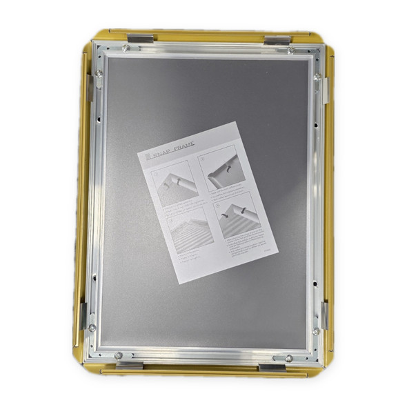 Gold snap frame opened on all four sides with the instruction sheet inside
