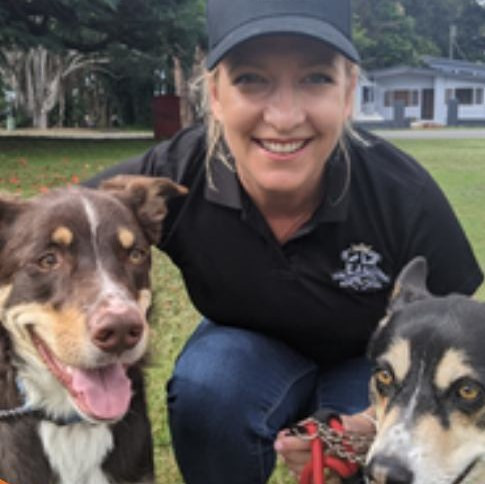 Huds and Toke co-founder Emma Gibbons smiling with two dogs on the grass
