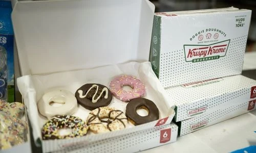 Krispy Kreme Doggie Doughnuts boxes stacked beside an open box of doughnuts for dogs
