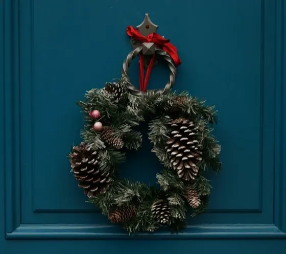 Evergreen Christmas wreath with pine cones on a door