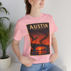 Pink Austin Texas Congress Avenue Bridge bat T-shirt featuring vintage-inspired MOMENT No. 007 artwork with bats emerging beneath the bridge at sunset.