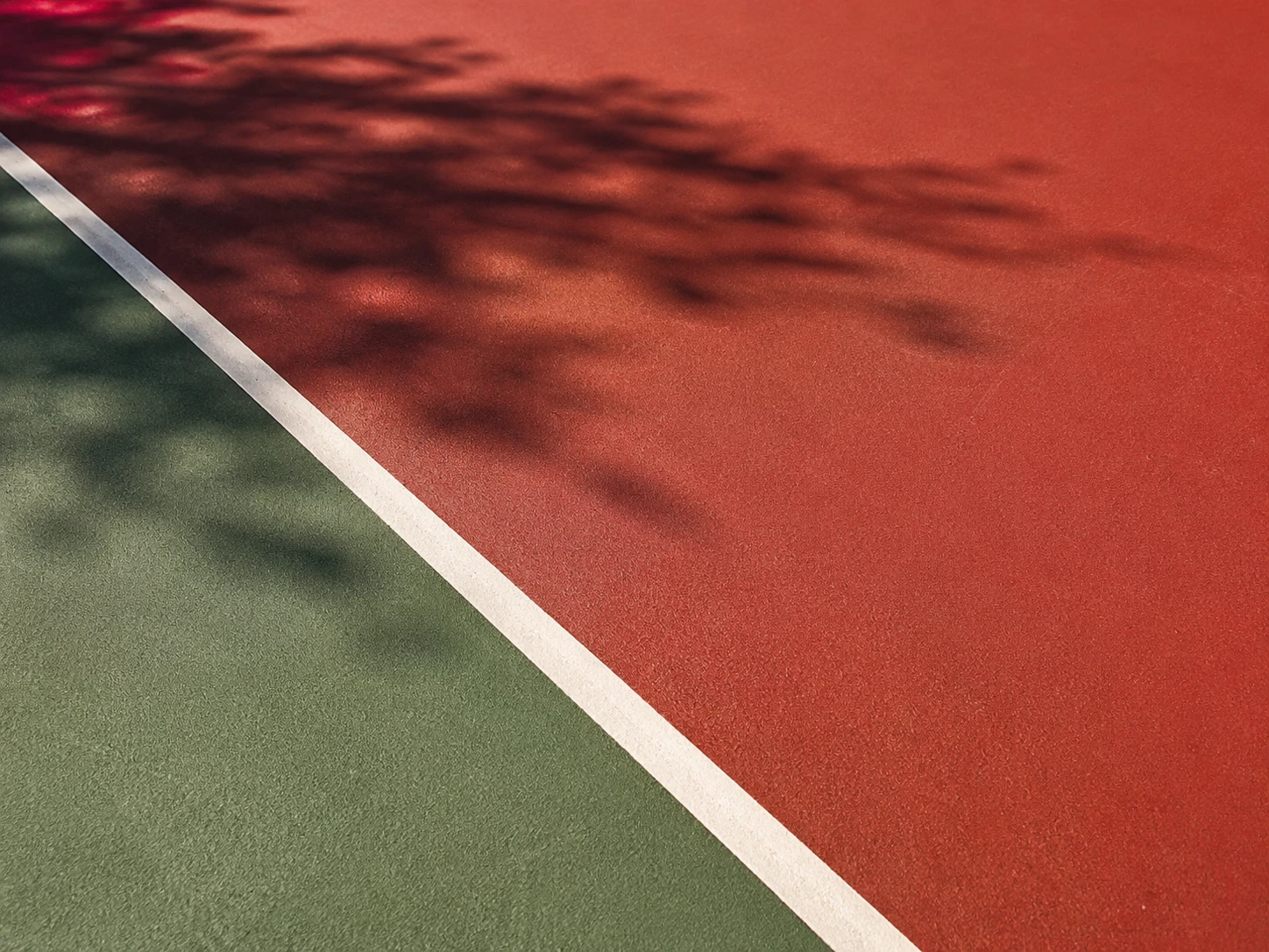 Tile-red and court-green acrylic surface retaining rich color in direct sun and tree shade