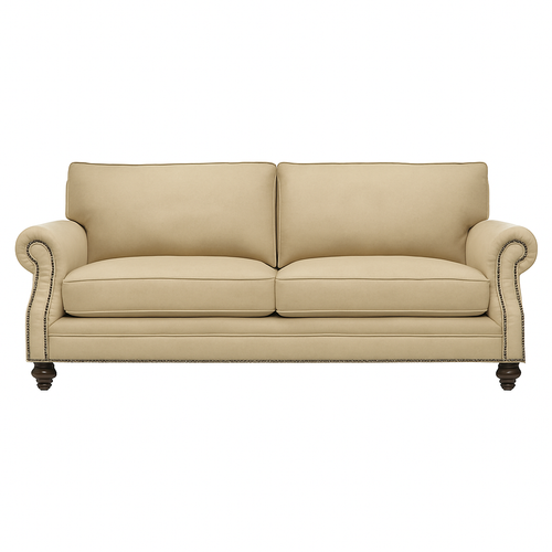 This elegant living room features the Frio Sofa and Armchair set in a matching beige premium upholstery. Designed with classic rolled arms, handcrafted nailhead trim, and dark wood legs, this collection blends timeless craftsmanship with modern comfort. The high-ceiling space is styled with natural sunlight, soft neutral tones, and luxurious décor, creating a sophisticated, inviting atmosphere. Perfect for luxury homes, upscale apartments, and high-end hospitality spaces, the Frio set elevates any interior with its refined aesthetic and customizable finishes.