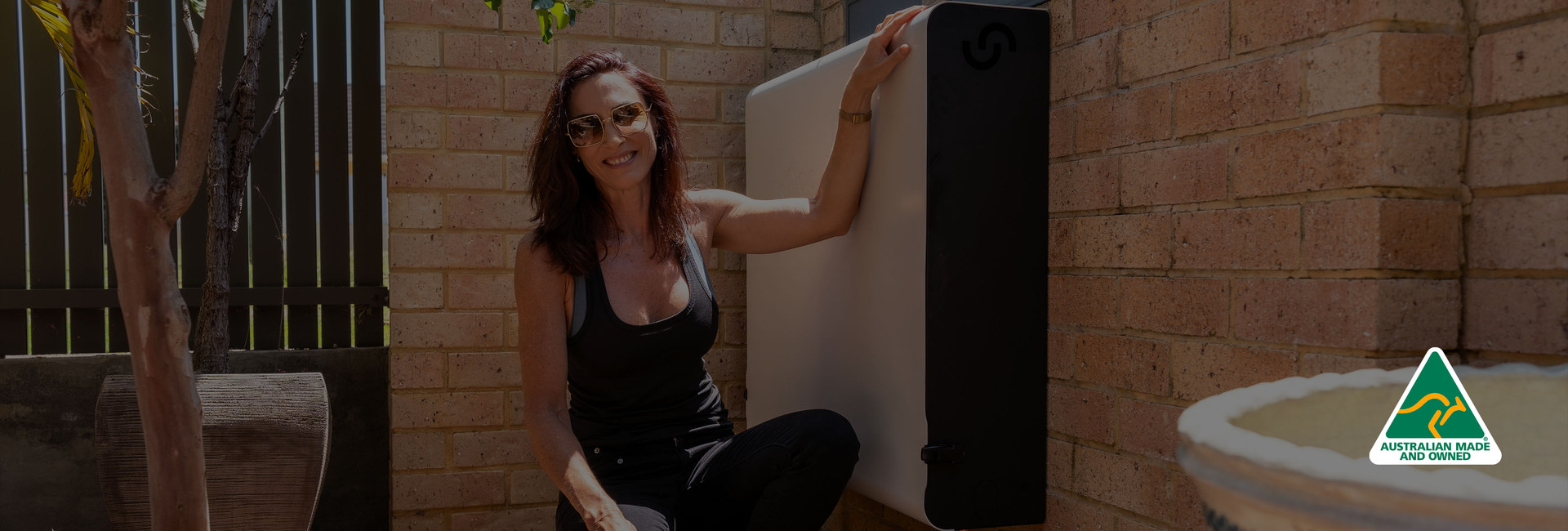 Satisfied customer posing next to her installed Cloudtap Design Series unit