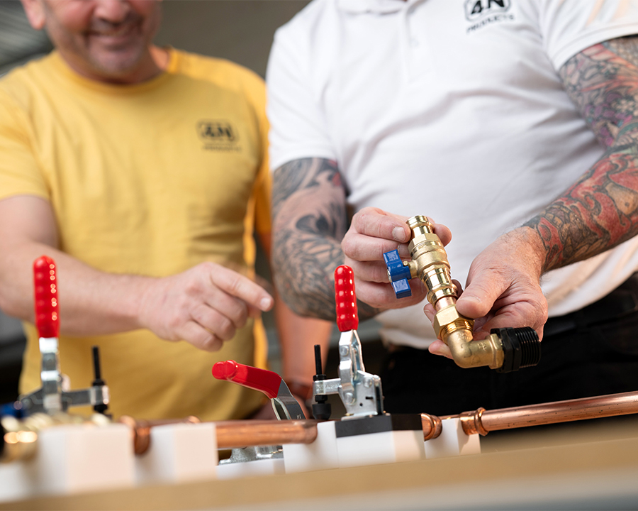 Two men work on a plumbing setup