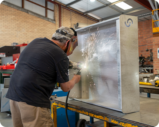 Man welding a Cloudtap Design Series unit frame