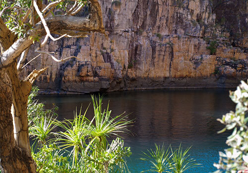Rocky cliffs and blue river surrounded by green foliage