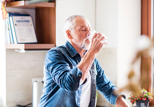 Older man drinking glass of water