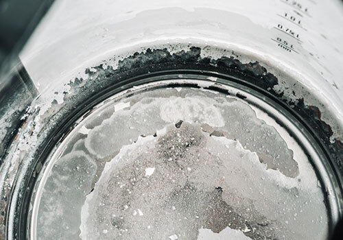 Close-up of limescale build-up on a metal surface