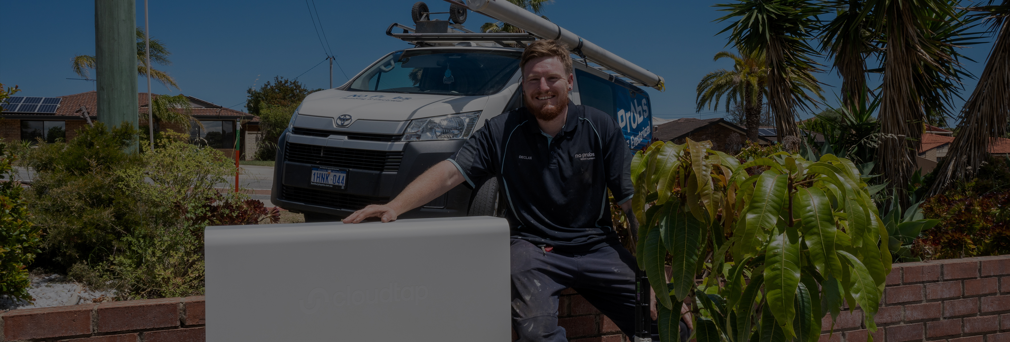 Plumber sitting next to an installed Design Series unit
