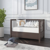 Nursery with a brown wood mini crib and ergoBean Basics Mini5 Dual -Stage Breathable Mini Crib Mattress.