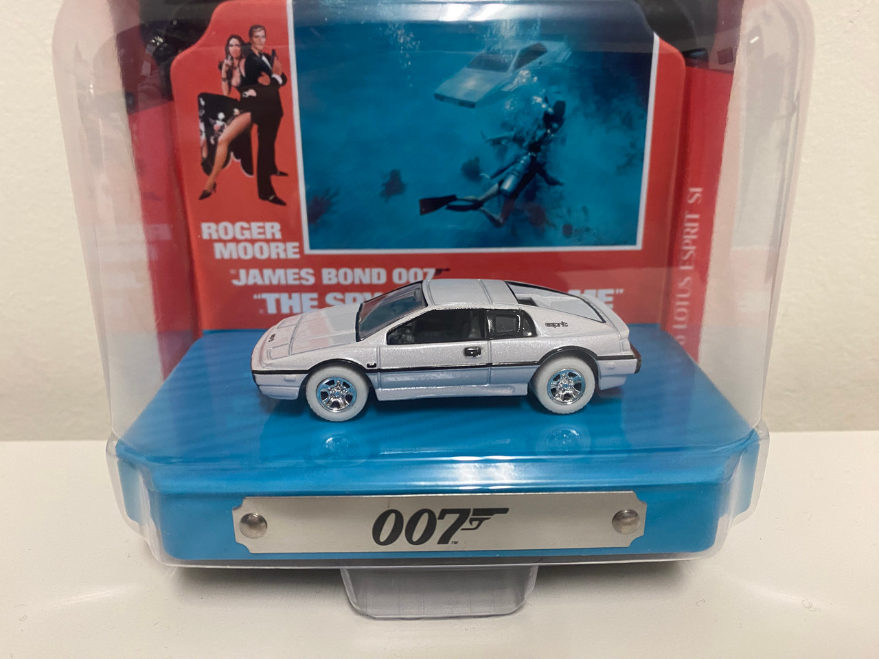 CHASE CAR 1976 Lotus Esprit S1 White with Collectible Tin Display "007" (James Bond) "The Spy Who Loved Me" (1977) Movie (10th in the James Bond Series) 1/64 Diecast Model Car by Johnny Lightning