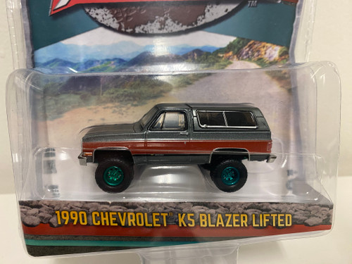 CHASE CAR 1/64 Greenlight 1990 Chevrolet K5 Blazer 1500 Lifted Gray Metallic with Fire Red and Black Stripes Diecast Car Model