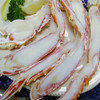 Split king crab legs on a plate with sliced lemons.