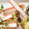 Packed-full split king crab legs arrange with lemons and salad.