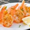 Shrimp on a bamboo skewer with lemon slice.