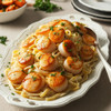 A delicious scallop fettuccine dish served on a stylish white platter.