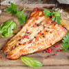 A smoked Copper River king salmon tail portion marbled with natural oils on a cutting board.