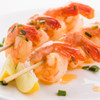 Shrimp on a bamboo skewer with lemon slice.