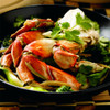 Dungeness crab legs & claws in a pan with vegetables.