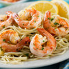 Delicious spot shrimp in a bed of noodles with lemon slices.