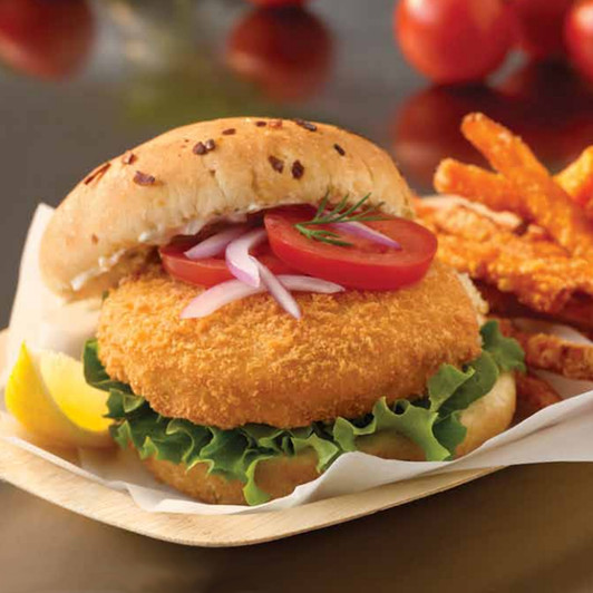 Alaska halibut burger patty sandwich with lettuce, tomato, & red onions.