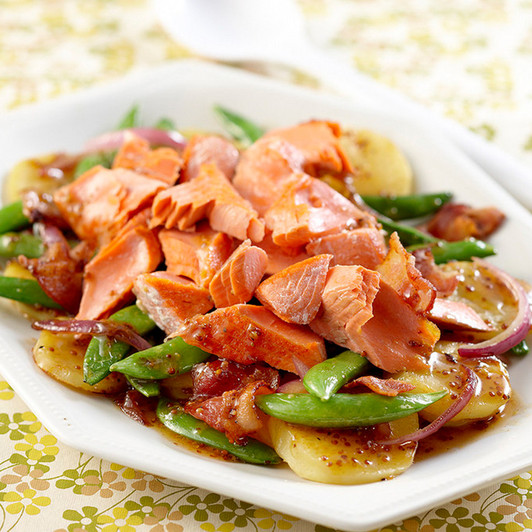 Alaska king salmon meat on top a warm salad mix.