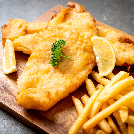 Battered cod with french fries and lemon wedges.