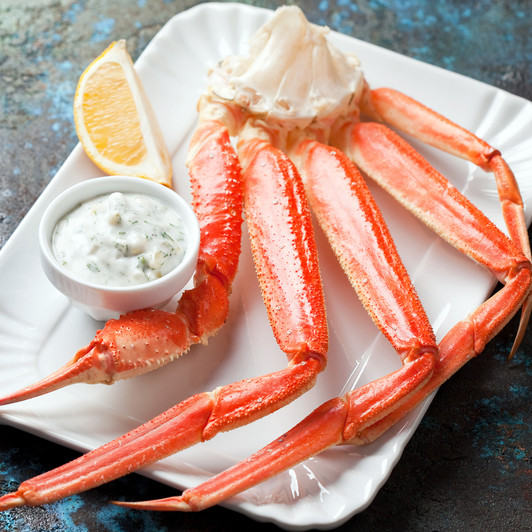 Alaska Opilio snow crab cluster with dipping sauce & lemon wedge.