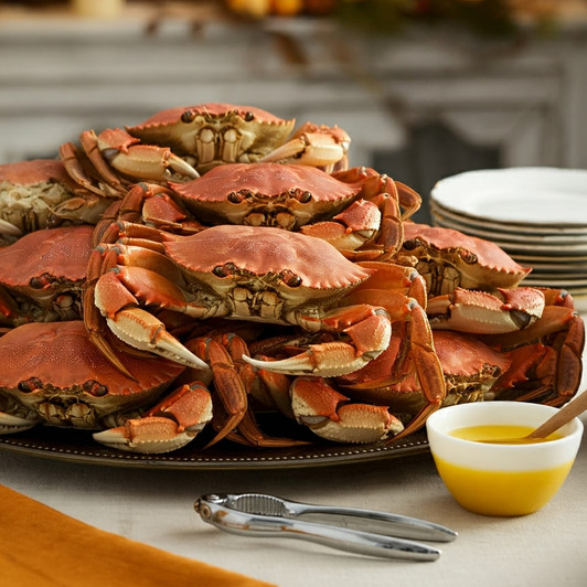 A large serving platter piled with whole-cooked Dungeness crab.