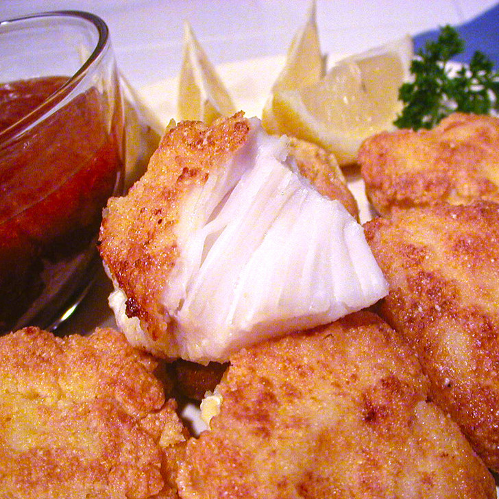 Breaded Alaska halibut cheeks with cocktail sauce & lemons.