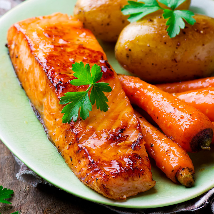 A delicious-looking dish of Copper River King salmon, garden-picked carrots, & small baked potatoes.
